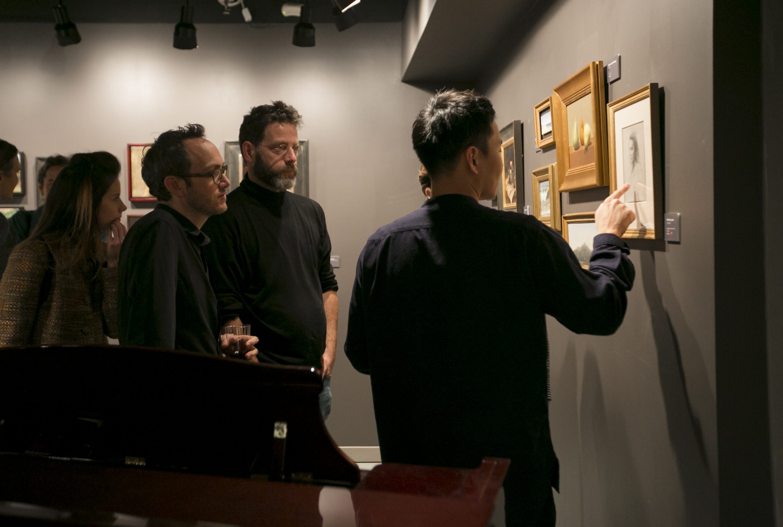 Artists and founder of Grand Central Atelier, Jacob Collins (C), look at artwork at the opening of the 