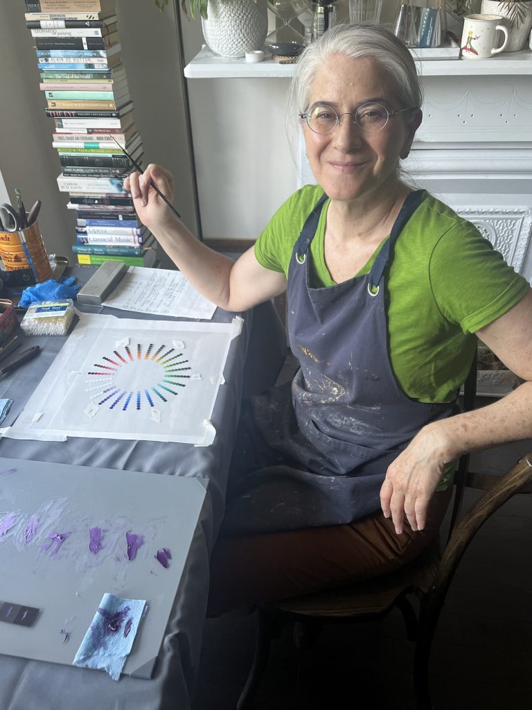 Milène Fernandez paints a color wheel during a workshop with the artist, Carlos Madrid at her Jersey City apartment in June 2024.